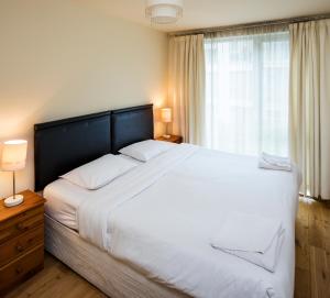 una camera da letto con un grande letto bianco e una finestra di Fitzwilliam Point a Dublino