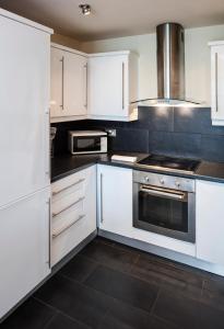 a kitchen with white cabinets and a stove at Fitzwilliam Point in Dublin