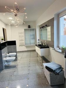 a bathroom with two sinks and a toilet and a chandelier at Mulberry House in Gdańsk
