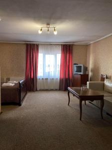 une chambre d'hôtel avec un canapé et une table dans l'établissement Viktoria Hotel, à Obroshino
