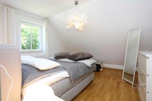 a bedroom with a bed with pillows and a window at Neu Reet Ferienhaus Svantevit in Lohme