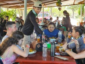 un grupo de personas sentadas en una mesa comiendo comida en Hostal Sol de Verano Doña Lilia, en Villavieja