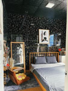 a bedroom with a bed and a black wall at Lavie House in Da Lat +19 photos