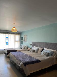 um quarto com 2 camas e um lustre em Las Bayas Home Suites em Esquel