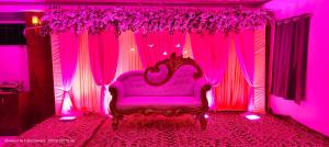 a purple room with a bed and pink curtains at The Ashiyana Inn Hotel in Patna