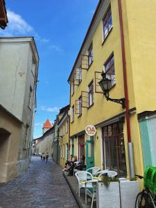 une rue pavée avec des personnes assises à l'extérieur des bâtiments dans l'établissement Charming apartment in Tallinn old town!, à Tallinn