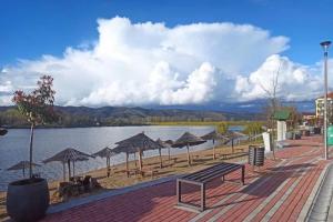 a beach with umbrellas and a body of water at Apartmani Royal in Veliko Gradište