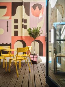 Zimmer mit einem Tisch und Stühlen auf einem Balkon in der Unterkunft Max Brown Hotel Canal District, part of Sircle Collection in Amsterdam
