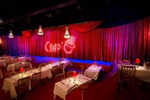 une salle à manger avec des tables et des rideaux rouges et violets dans l'établissement Manoir Hamme, à Hamme