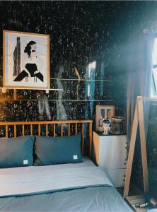 a bedroom with a bed with a picture on the wall at Lavie House in Da Lat