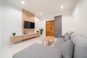 uma sala de estar com um sofá e uma televisão em New 2BR townhome 350M walk to kata beach em Praia de Kata