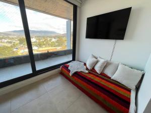 uma sala de estar com um sofá e uma televisão de ecrã plano em Penthouse en Papudo Alto - Chagual em Papudo