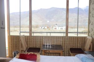 a bedroom with a view of a mountain from a window at The hidden heaven cottage pangong merak in Meruk