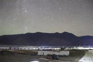 a starry night with mountains in the background at The hidden heaven cottage pangong merak in Meruk