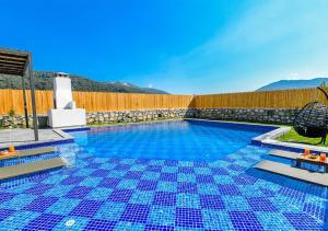 una piscina con azulejos azules en el suelo en Villa Sade 2 / Kalkan, en Kas