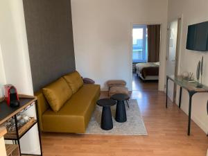 uma sala de estar com um sofá e duas mesas em Coco’s place em Antuérpia
