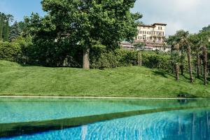 Ein großes Wasserbecken mit einem Gebäude im Hintergrund in der Unterkunft Paladina Hotel in Pura