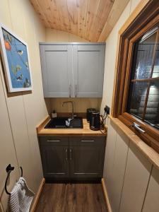 een kleine keuken met een wastafel en een raam bij Rectory Roost in Spalding