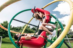 twee kinderen op een achtbaan in een park bij Paladina Hotel in Pura