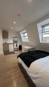 a bedroom with a large bed and a kitchen at Halloway Guest Studio 54 in London