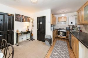 een keuken met houten kasten en een aanrecht bij Well Equipped Apartment for Relocators and Contractors in Reading