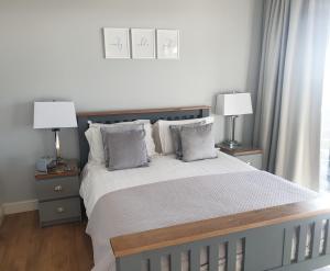 a bedroom with a large bed with two lamps at The Waters Edge in Lee-on-the-Solent
