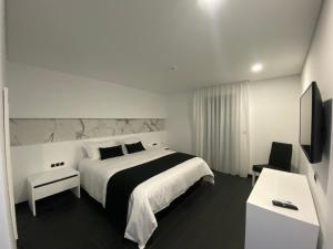 Cette chambre comprend un grand lit et une télévision. dans l'établissement The Rock Hostel, à Ponta Delgada
