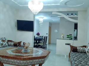 sala de estar con mesa y sofá en Appart-ines l'Oasis du confort et luxe, en Oujda