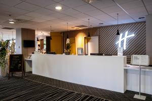 a lobby with a white counter in a building at Holiday Inn - Strasbourg - Nord, an IHG Hotel in Schiltigheim