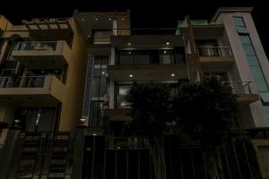 a tall apartment building at night at OYO Townhouse 1071 Hotel Metro Inn Residency Near ISKCON Temple Noida in Indirapuram