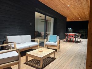 d'une terrasse avec un canapé, des chaises et une table. dans l'établissement Villas Vallée d'ASCO, à Moltifao