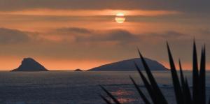 a sunset over the ocean with a mountain in the background at Almar Punta Hermosa in Punta Hermosa +4 photos