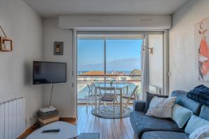 a living room with a couch and a table and a balcony at T2 Vue Mer Arcachon in Arcachon