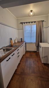 a kitchen with white cabinets and a sink and a window at Prowincja Dębki in Dębki