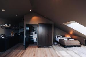 een slaapkamer met een bed in een kamer met een plafond bij Keflavik Cozy Apartments in Keflavík