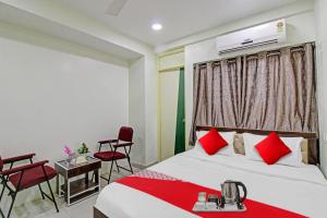 a hotel room with a bed and a table and chairs at Hotel Sunshine Inn in Nagpur