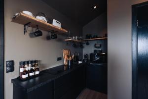 cocina con armarios negros y encimera negra en Keflavik Cozy Apartments, en Keflavík