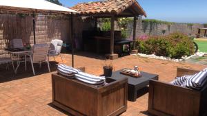 a patio with two chairs and a table and an umbrella at Hotel Casa Puccllana in Constitución