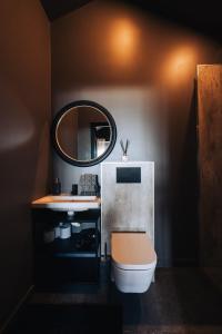 een badkamer met een wastafel, een spiegel en een toilet bij Keflavik Cozy Apartments in Keflavík