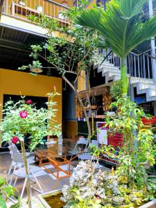 Q' Homestay Garden Villa في هوى: فناء مع طاولة ومجموعة من النباتات