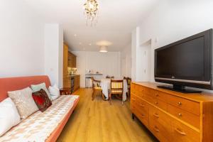 a living room with a couch and a flat screen tv at Bright 1BR Flat wPatio in Islington, Angel in London