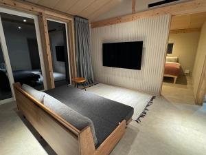 1 dormitorio con 1 cama y TV de pantalla plana en ARTISANAL, en Naoshima