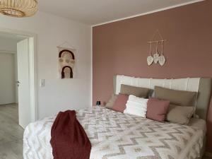 1 dormitorio con 1 cama grande y paredes de color rosa en Boho Appartement, en Bielefeld