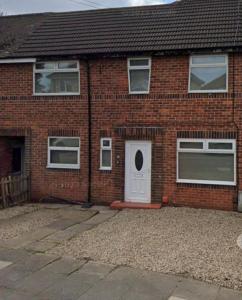 a brick house with a white door and a window at Daventry House Stockton by Horizon Stays in Stockton-on-Tees