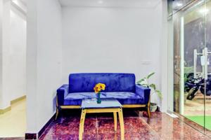 um sofá azul numa sala de estar com uma mesa em Super Capital O The Jumar em Silwai