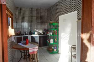 a small kitchen with a table and a refrigerator at Casa Mirante da Ilha in Arez