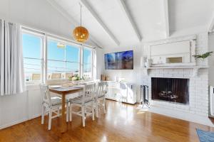 a dining room with a table and a fireplace at Virginia Way Cottage in Laguna Beach