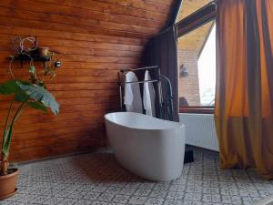 Kera cottages kazbegi في كازباجي: حمام مع حوض استحمام أبيض كبير في الغرفة