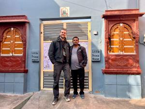 two men standing in front of a blue building at Little prince guest house & homestay in Bikaner