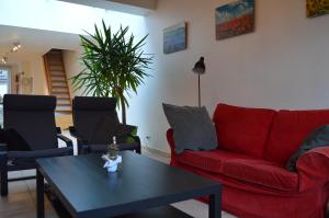 salon z czerwoną kanapą i stołem w obiekcie Fine Fleur w mieście Geraardsbergen
